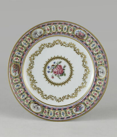 Assiette à décor polychrome de rubans torsadés et de fleurs