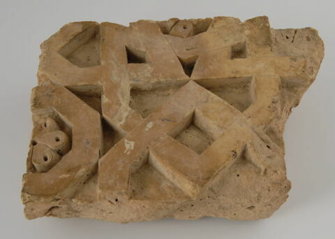 Fragment de décor architectural rectangulaire à entrelacs géométriques et rosettes