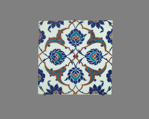 Carreau au réseau cruciforme de fleurons bifides rumi, de palmettes et de fleurs épanouies