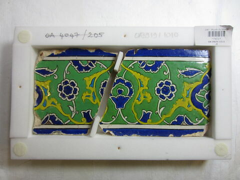 Carreau au rinceau de rumi enfermant des fleurettes et des fleurs épanouies