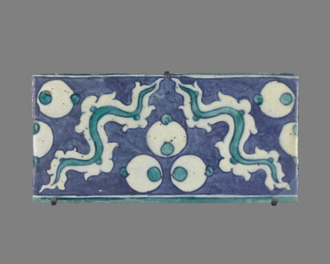 Carreau de bordure à triple ocelles et rubans sinueux sur fond bleu