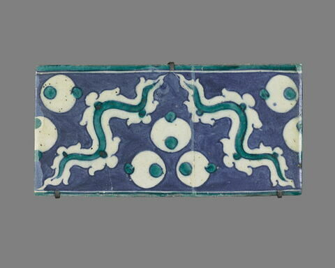 Carreau de bordure à triple ocelles et rubans sinueux sur fond bleu