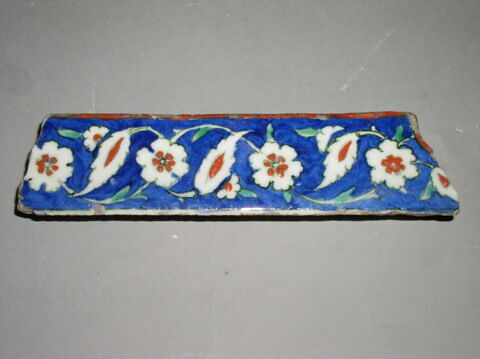 Fragment d'un écoinçon à rosettes et feuilles dentelées sur fond cobalt