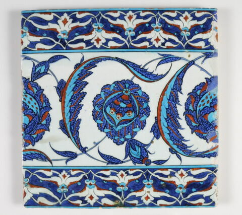 Carreau de bordure à rinceau meublé de fleurs composites et de feuilles saz